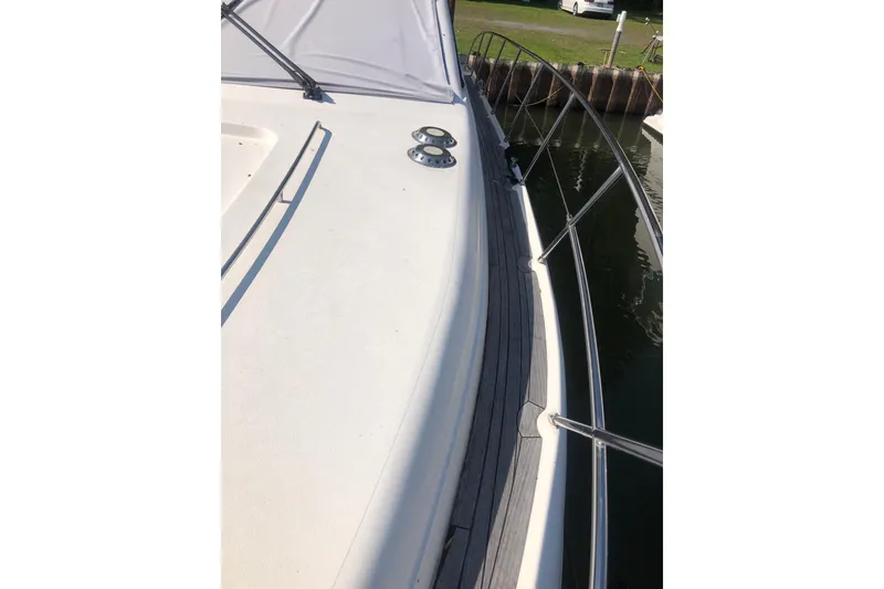 Slide: The Image of 2002 Birchwood Challenger 460 Flybridge yacht deck with railing, docked by water. - 13
