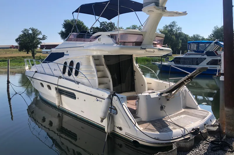 Slide: The Image of 2003 Birchwood 460 FB yacht docked at a marina, featuring a spacious deck and elegant design. - 2