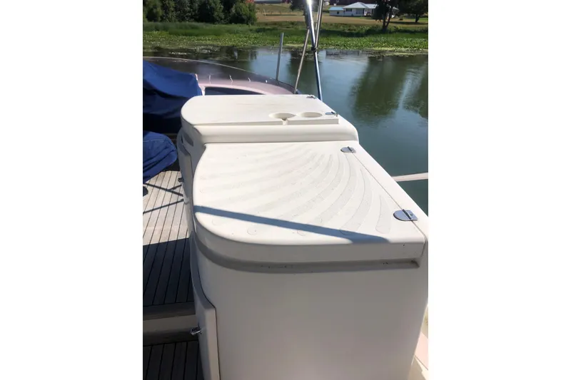Slide: The Image of 2002 Birchwood Challenger 460 Flybridge deck with white storage unit by the water. - 28