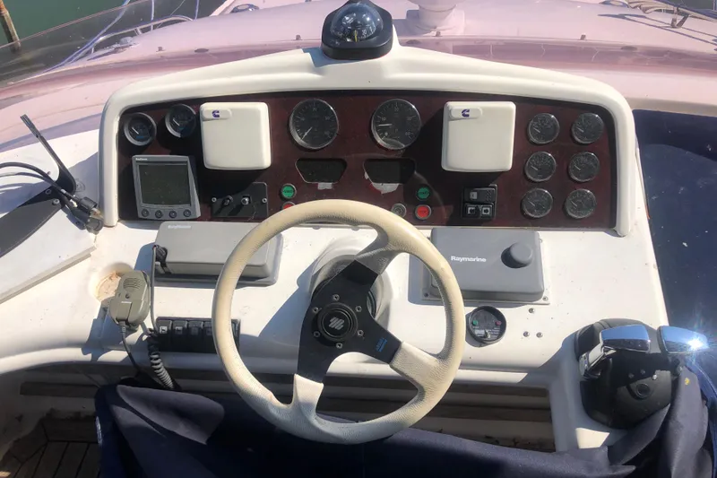 Slide: The Image of Control panel of a 2002 Birchwood Challenger 460 Flybridge boat with steering wheel and instruments. - 33