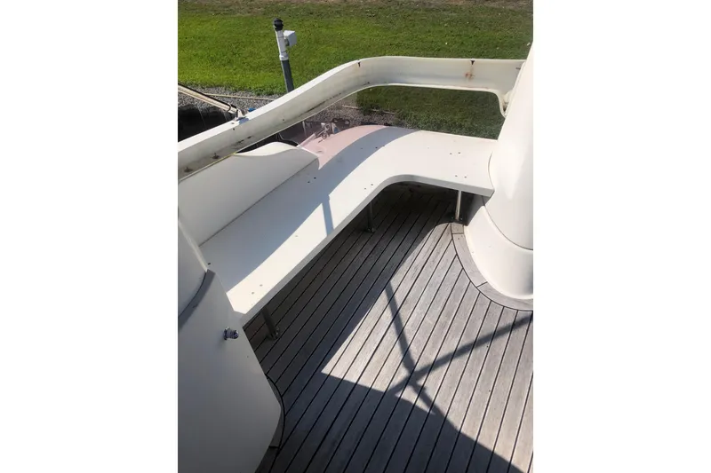 Slide: The Image of Flybridge seating area on 2002 Birchwood Challenger 460, featuring wooden deck and curved bench. - 47