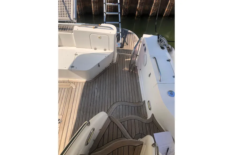 Slide: The Image of Teak deck of 2002 Birchwood Challenger 460 Flybridge yacht, featuring elegant seating and ladder. - 50