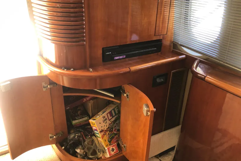 Slide: The Image of 2002 Birchwood Challenger 460 Flybridge interior with wooden cabinet and board games. - 57