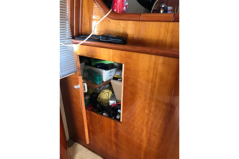 Slide: The Image of Wooden cabinet with open door revealing storage on Birchwood Challenger 460 Flybridge, 2002 model. - 63