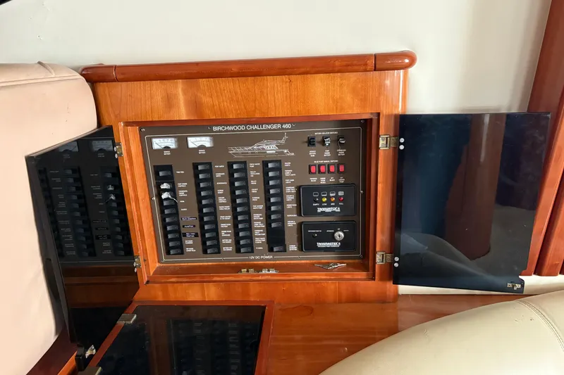 Slide: The Image of Control panel of a 2002 Birchwood Challenger 460 Flybridge yacht, featuring various switches and gauges. - 69