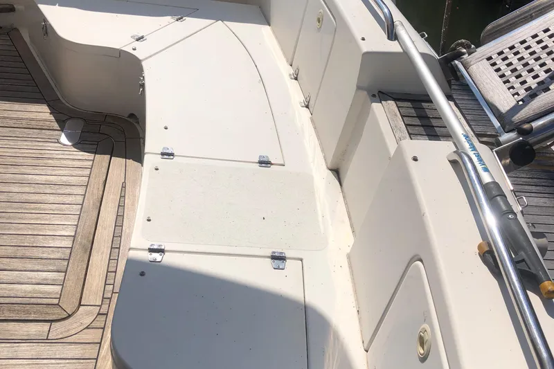 Slide: The Image of Deck area of a 2003 Birchwood 460 FB boat with wooden flooring and storage compartments. - 7