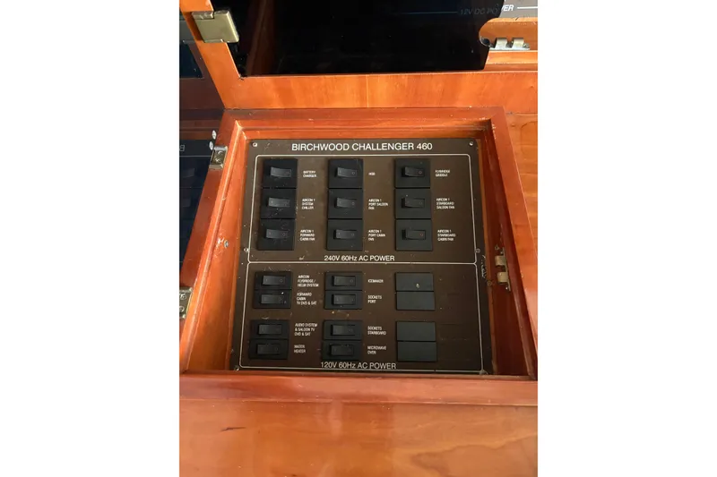 Slide: The Image of Electrical panel of 2002 Birchwood Challenger 460 Flybridge yacht, featuring various power switches. - 70