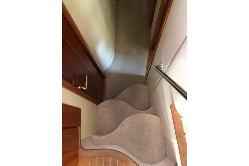 Slide: The Image of Staircase inside 2002 Birchwood Challenger 460 Flybridge yacht, featuring wooden and carpeted steps. - 79