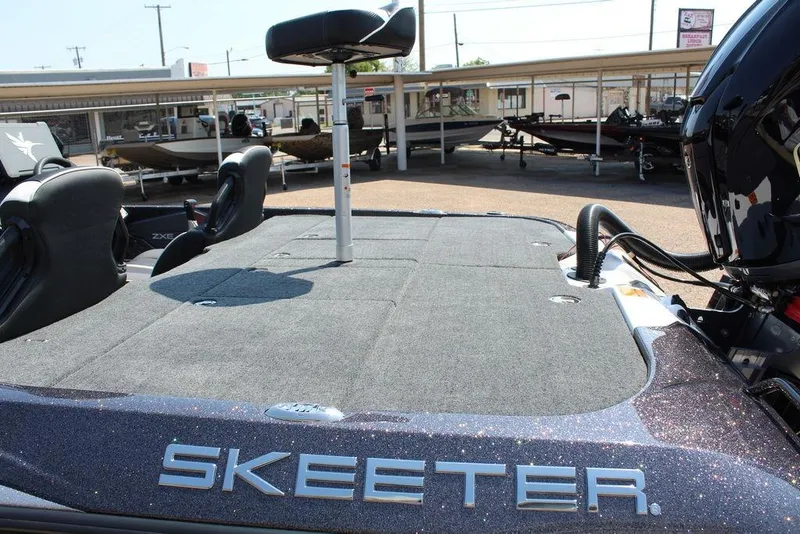 Slide: The Image of 2026 Skeeter ZXE20 boat deck with seating and motor, displayed outdoors. - 21