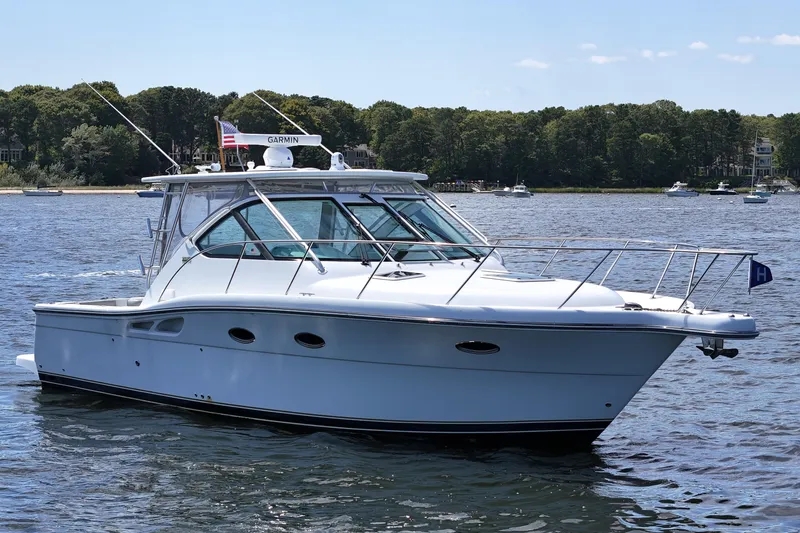 Slide: The Image of 2006 Tiara 3200 Open yacht on calm water, surrounded by lush greenery. - 0