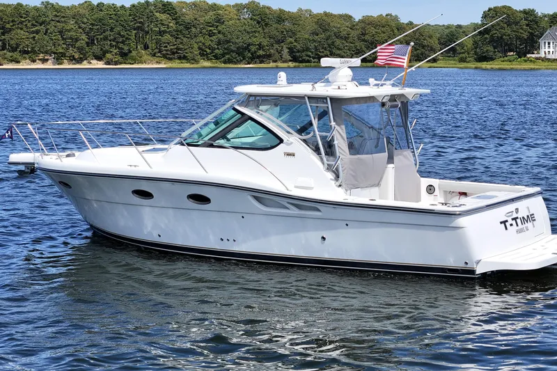 Slide: The Image of 2006 Tiara 3200 Open yacht on calm water, American flag, scenic background. - 1