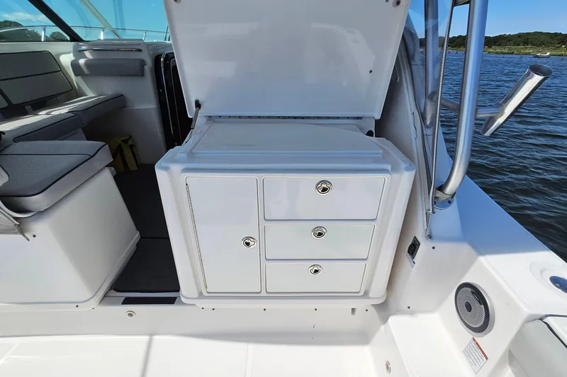 Slide: The Image of 2006 Tiara 3200 Open boat interior with storage drawers and seating, near water. - 17