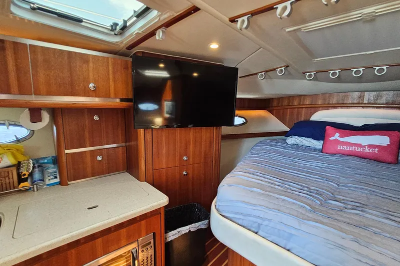 Slide: The Image of 2006 Tiara 3200 Open cabin interior with bed, TV, and wooden cabinetry. - 38