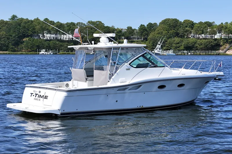 Slide: The Image of 2006 Tiara 3200 Open yacht on calm water, surrounded by lush greenery. - 4