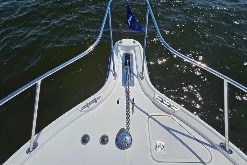 Slide: The Image of Bow of 2006 Tiara 3200 Open yacht with anchor chain and railing on water. - 44