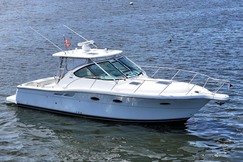 Slide: The Image of 2006 Tiara 3200 Open yacht on calm water, featuring sleek design and American flag. - 7