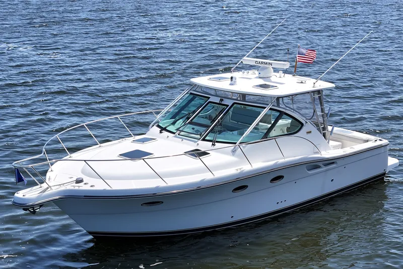 Slide: The Image of 2006 Tiara 3200 Open yacht on calm water, featuring sleek design and American flag. - 9