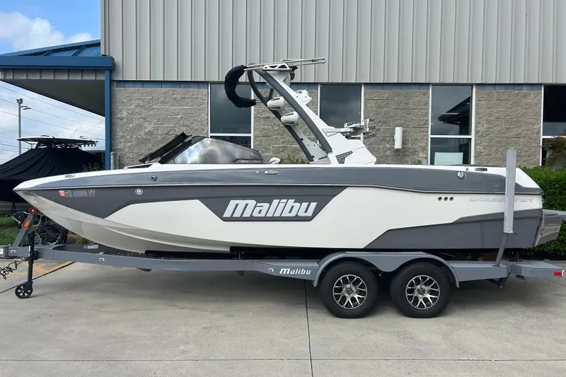 Slide: The Image of 2022 Malibu Wakesetter 23 LSV boat on trailer, parked outside a building. - 0