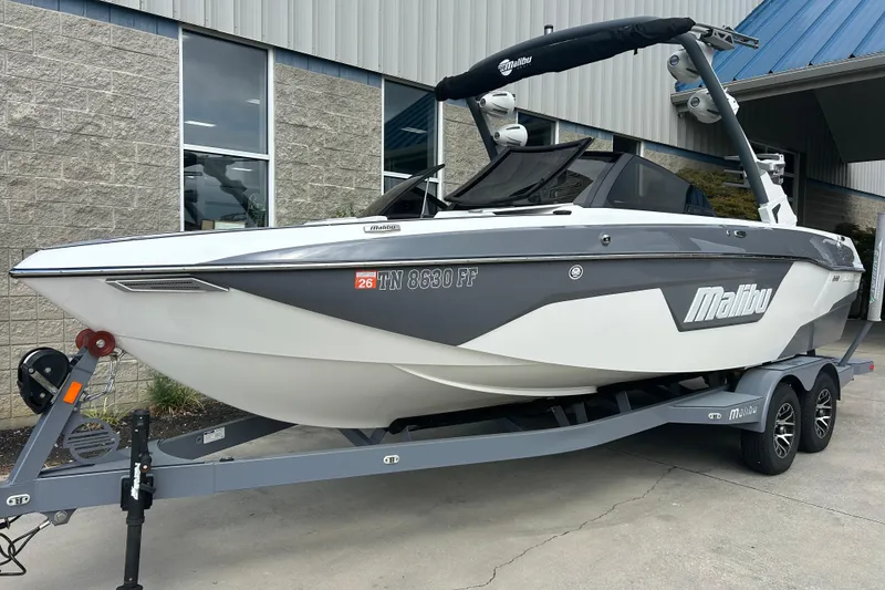 Slide: The Image of 2022 Malibu Wakesetter 23 LSV boat on trailer, parked outside a building. - 1