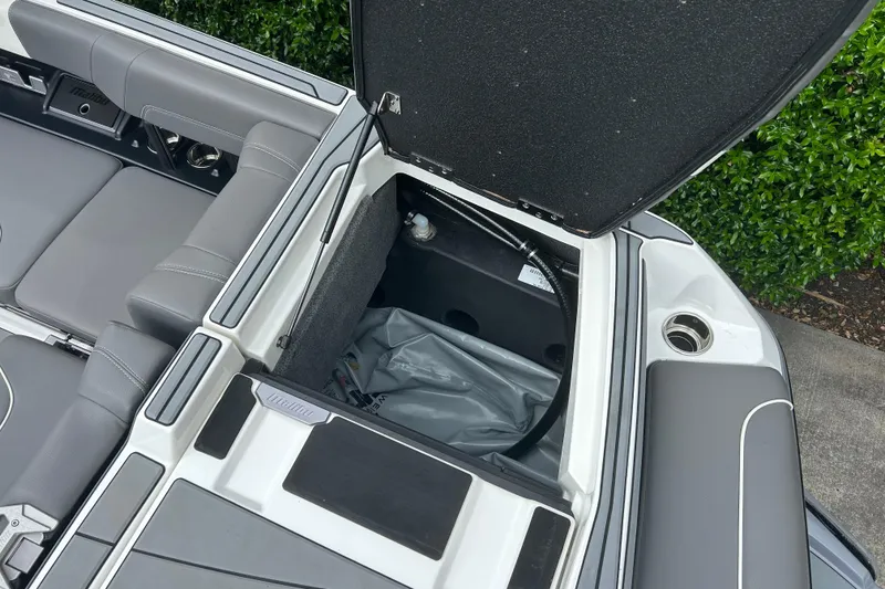 Slide: The Image of 2022 Malibu Wakesetter 23 LSV open storage compartment with gray seating and sleek design. - 12