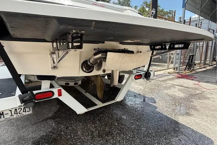 Slide: The Image of Rear view of a 2011 Axis A20 boat on a trailer, showing exhaust and propeller. - 13