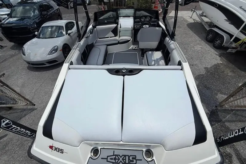 Slide: The Image of 2011 Axis A20 boat interior with seating, parked near luxury cars. - 14