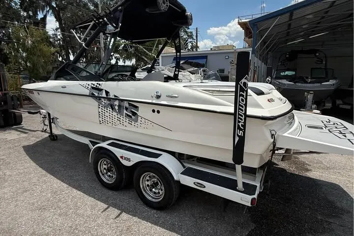 Slide: The Image of 2011 Axis A20 boat on trailer, parked outdoors, featuring sleek design and graphics. - 3