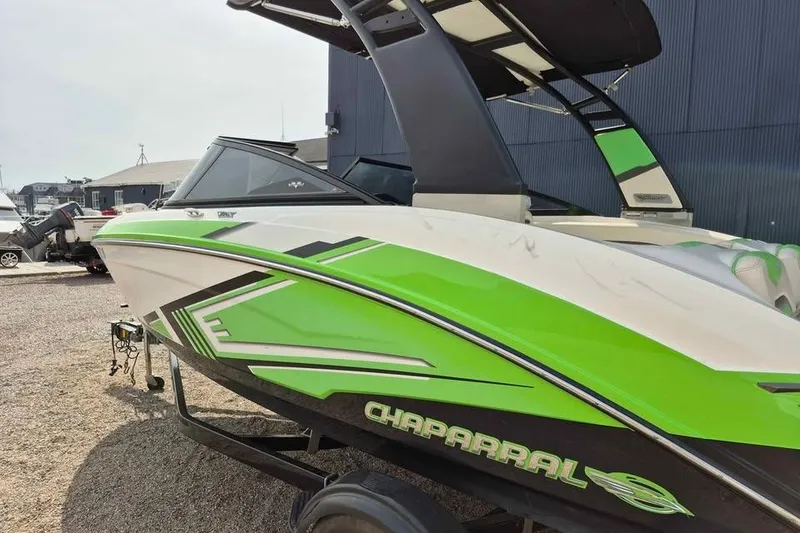 Slide: The Image of 2017 Chaparral Vortex 203 VRX boat with green accents, parked outdoors. - 4