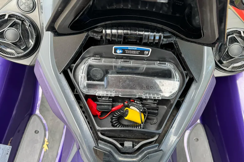 Slide: The Image of 2021 Sea-Doo RXT-X 300 storage compartment with safety equipment and waterproof case. - 13