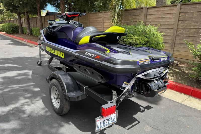 Slide: The Image of 2021 Sea-Doo RXT-X 300 jet ski on trailer, parked outdoors. - 3