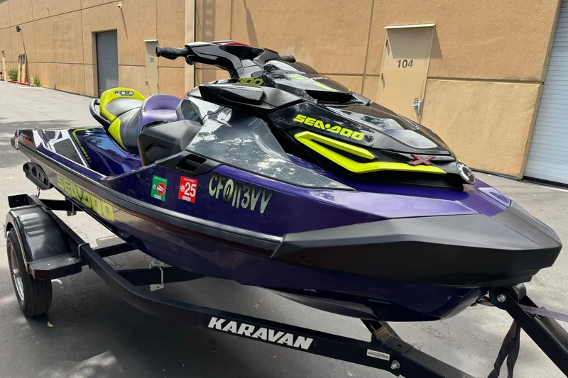 Slide: The Image of 2021 Sea-Doo RXT-X 300 jet ski on a Karavan trailer, parked outdoors. - 7