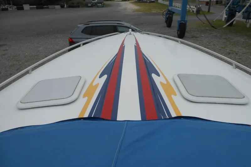 Slide: The Image of 2003 Formula 271 FASTech boat with colorful deck design and blue cover. - 2