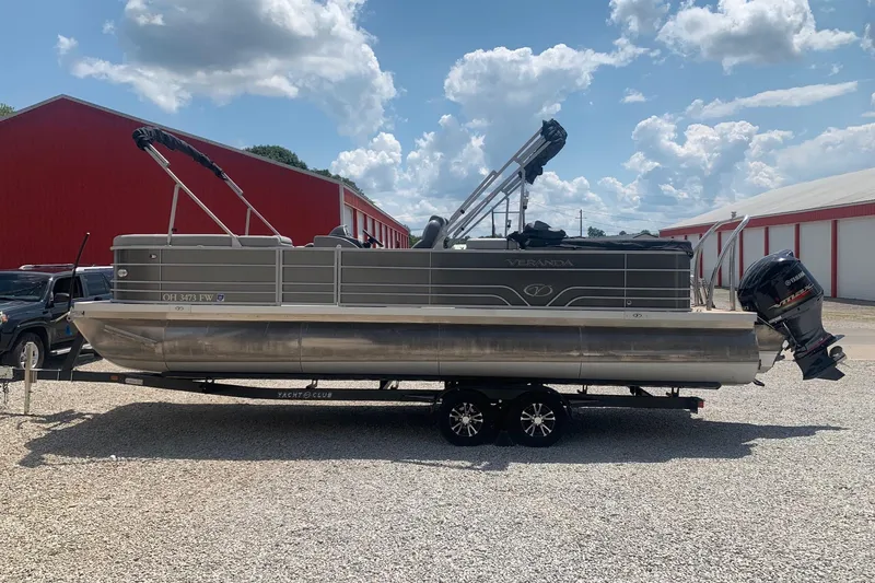 Slide: The Image of 2018 Veranda Relax VR 25 RC pontoon boat on trailer, parked outdoors. - 2