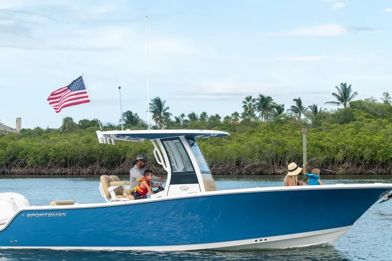 The Image of 2026 Sportsman Open 252 Center Console boat cruising with family, American flag waving. - 0