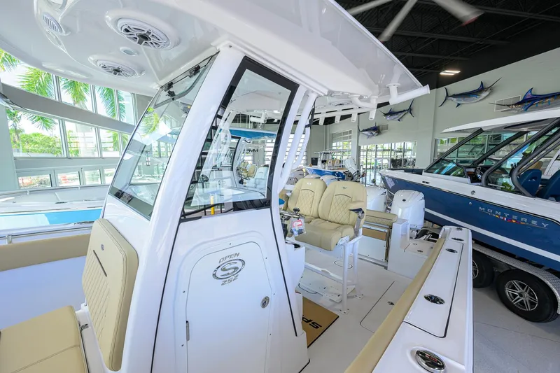 Slide: The Image of 2026 Sportsman Open 252 Center Console boat interior in showroom, featuring luxurious seating and modern design. - 16