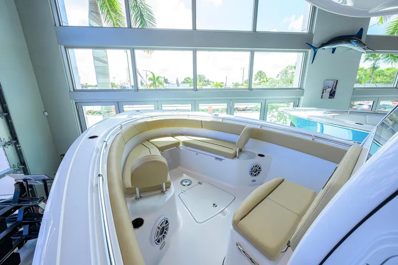 Slide: The Image of 2026 Sportsman Open 252 Center Console boat interior with beige seating in a showroom. - 18