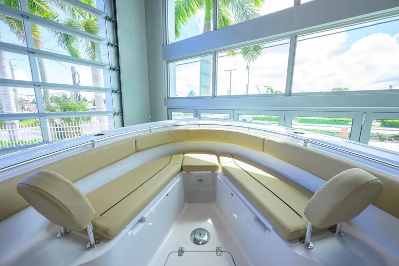 Slide: The Image of 2026 Sportsman Open 252 Center Console boat interior with beige seating and large windows. - 23