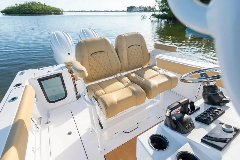 Slide: The Image of 2026 Sportsman Open 252 Center Console boat interior with dual tan seats and control panel. - 6