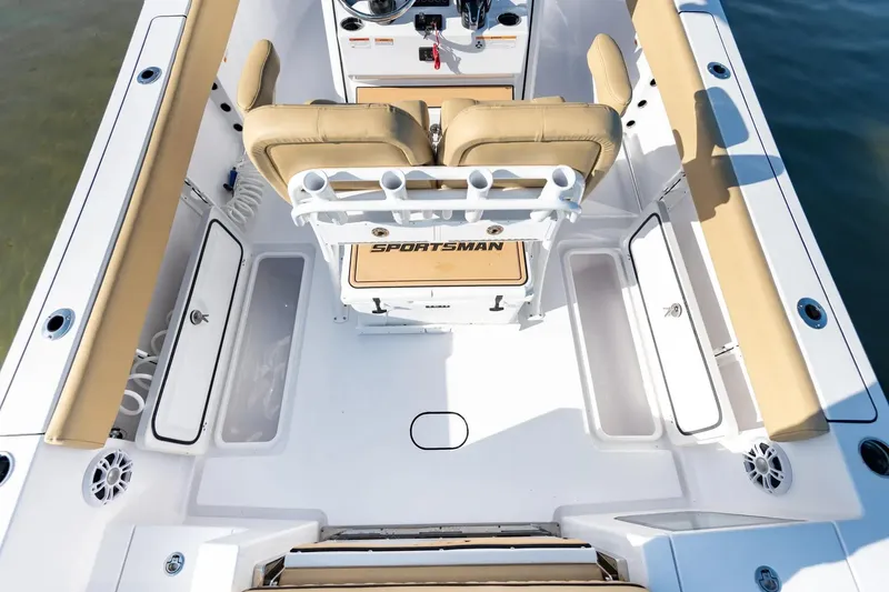 Slide: The Image of 2026 Sportsman Open 252 Center Console boat interior with tan seating and rod holders. - 9