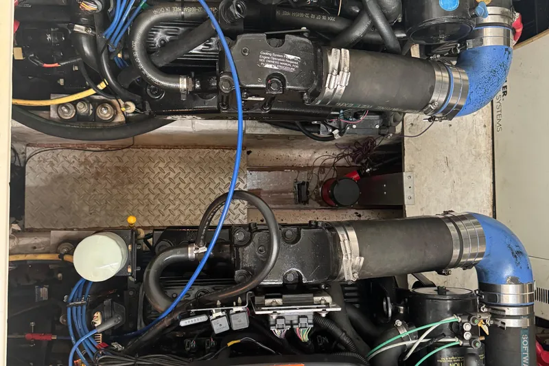 Slide: The Image of Engine compartment of a 2005 Cruisers Yachts 340 Express, showcasing mechanical components and hoses. - 28