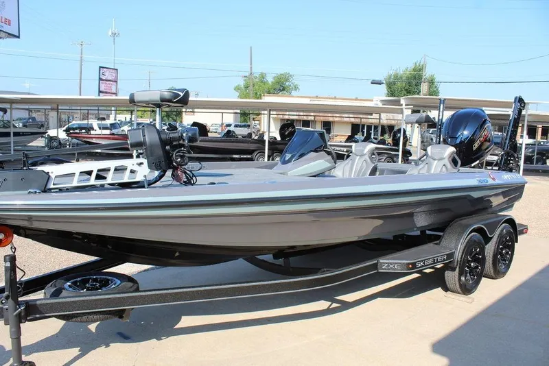 Slide: The Image of 2026 Skeeter ZXE21 fishing boat on trailer, displayed outdoors in a dealership lot. - 12