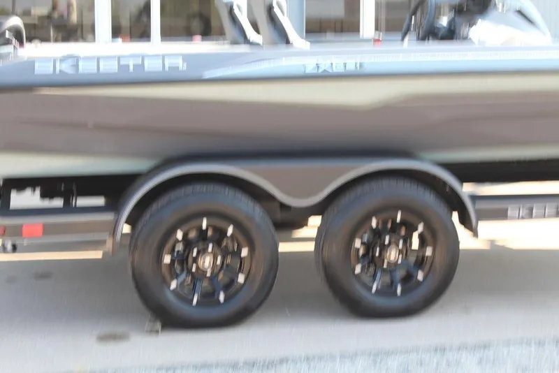 Slide: The Image of 2026 Skeeter ZXE21 boat trailer with dual black wheels, side view. - 4