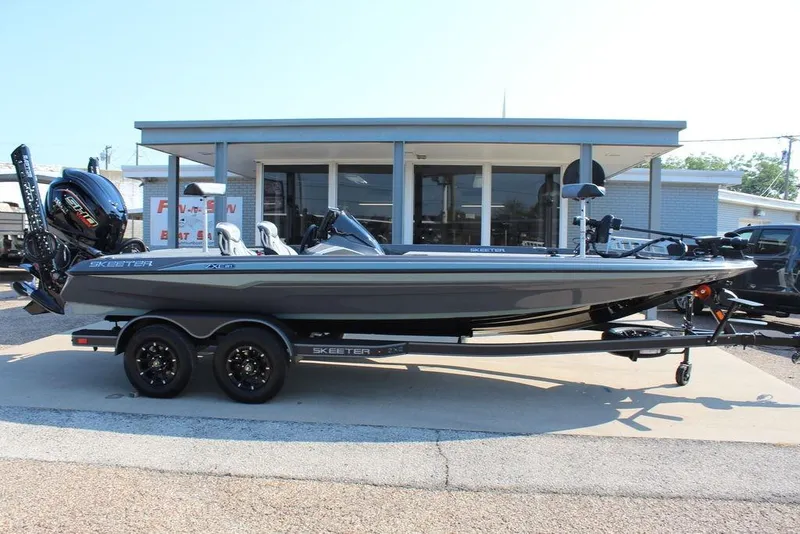 Slide: The Image of 2026 Skeeter ZXE21 boat on trailer, parked outside a showroom. - 5