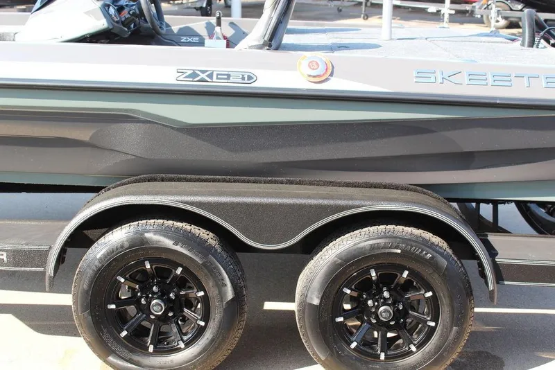 Slide: The Image of 2026 Skeeter ZXE21 boat on trailer with black wheels and sleek design. - 7