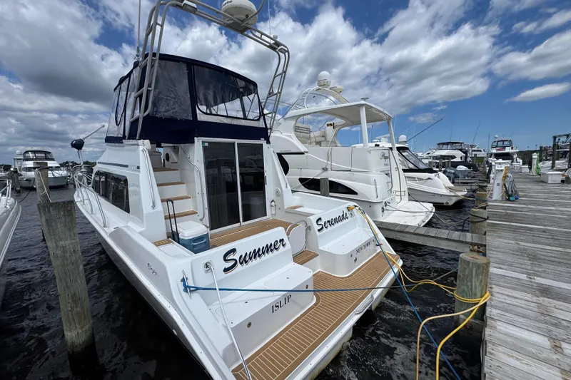 Slide: The Image of 1997 Mainship 40 Sedan Bridge docked at marina under cloudy sky. - 0