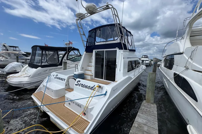 Slide: The Image of 1997 Mainship 40 Sedan Bridge docked at marina under cloudy sky. - 1