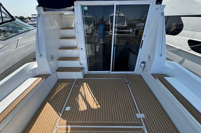 Slide: The Image of 1997 Mainship 40 Sedan Bridge yacht deck with sliding glass doors and wooden flooring. - 10