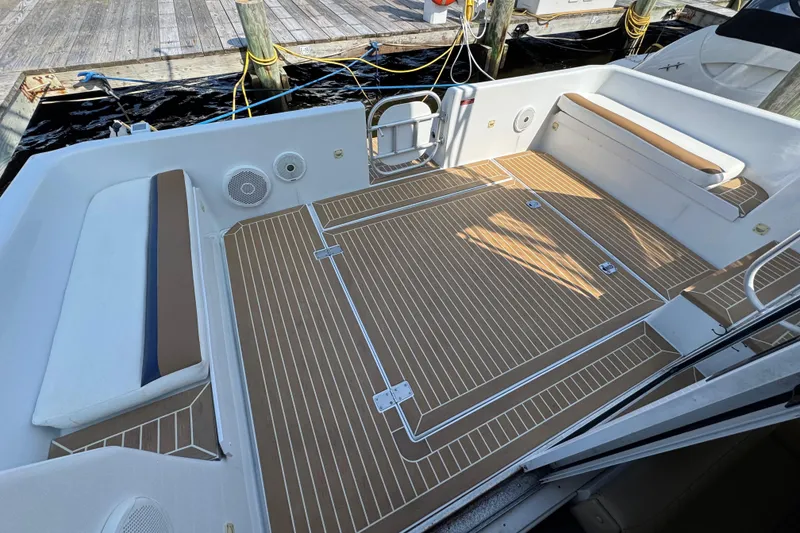 Slide: The Image of 1997 Mainship 40 Sedan Bridge boat deck with seating and wood-patterned flooring. - 11