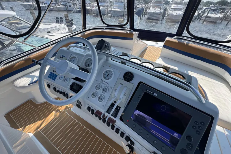 Slide: The Image of 1997 Mainship 40 Sedan Bridge helm with steering wheel, gauges, and navigation system. - 16