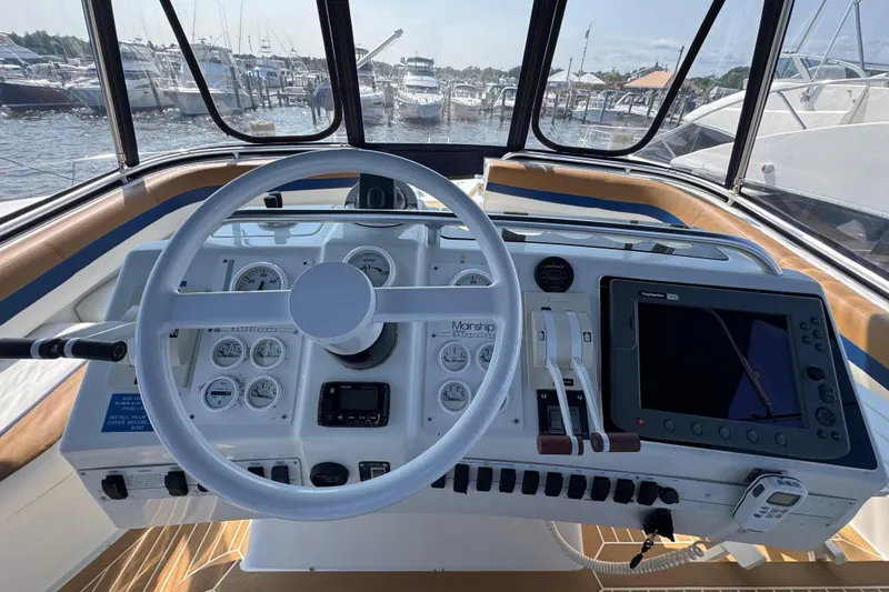 Slide: The Image of 1997 Mainship 40 Sedan Bridge helm with steering wheel, gauges, and navigation equipment. - 18